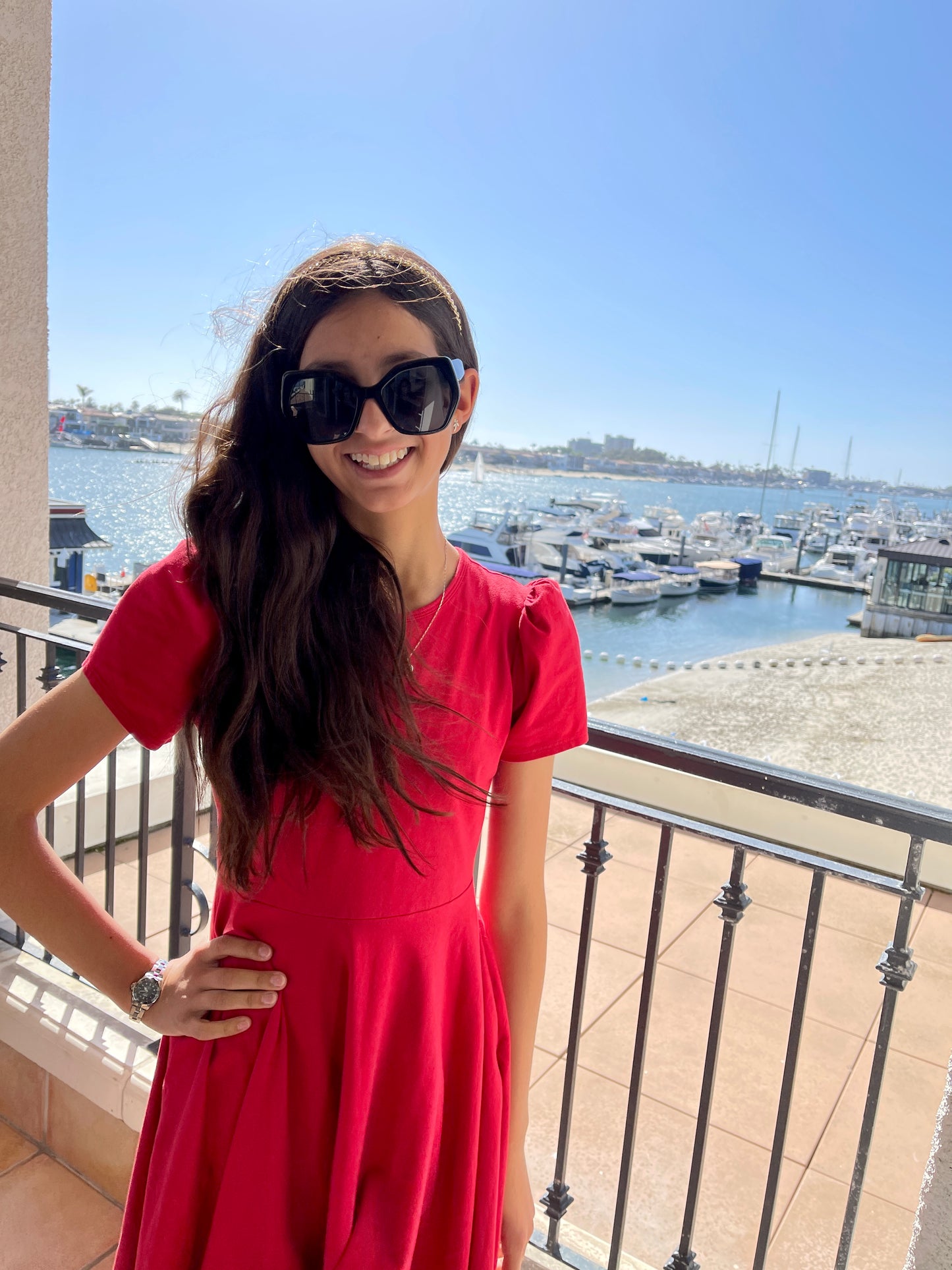 Little girl at the beach in a red dress.