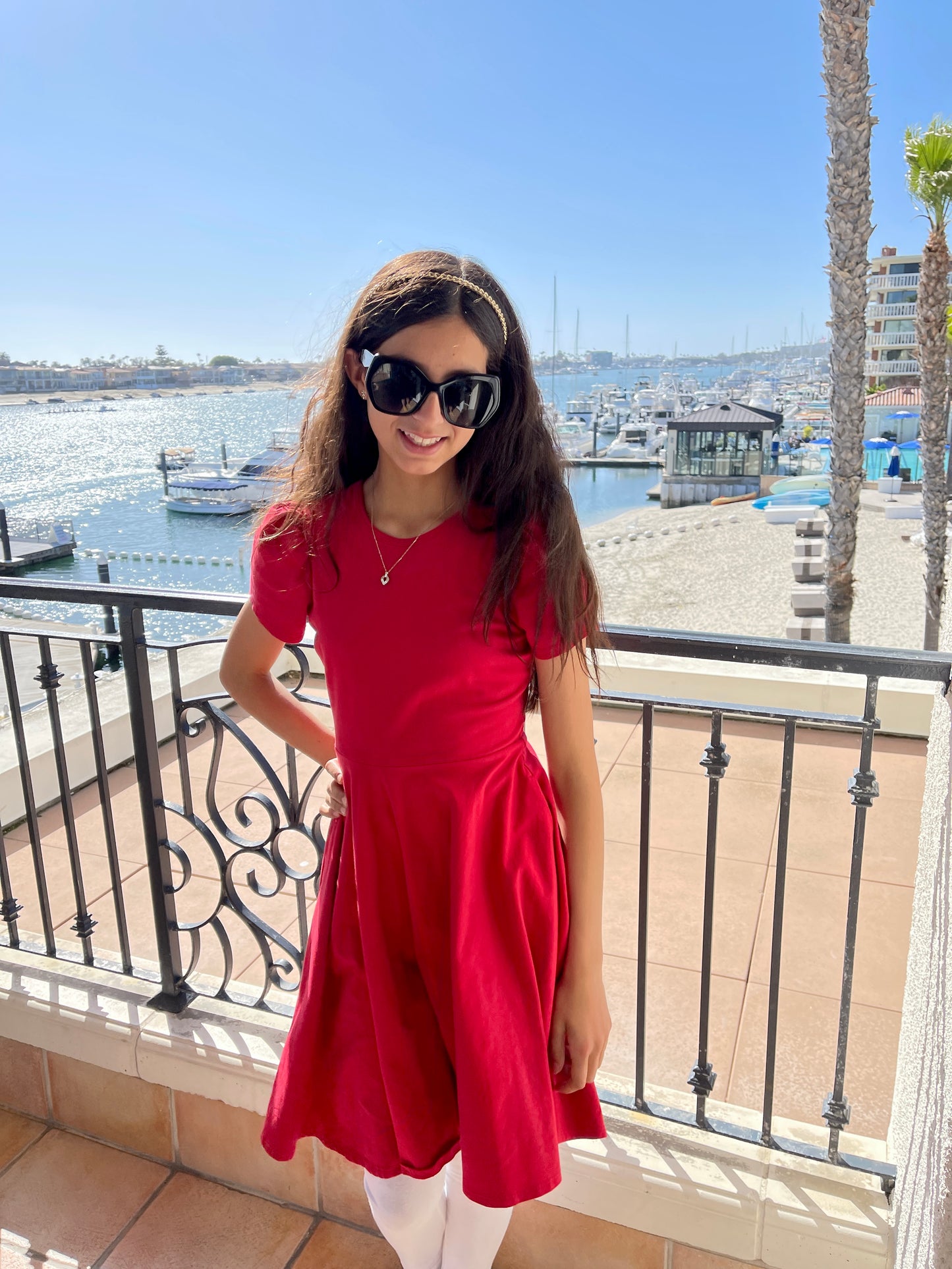 Little girl at the beach in a red dress.